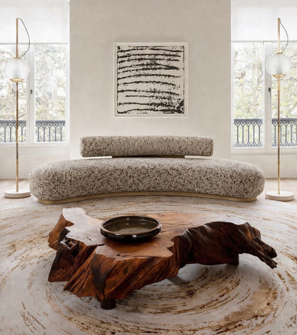 Modern living room with a curved sofa and wooden coffee table earthy palette unique design 